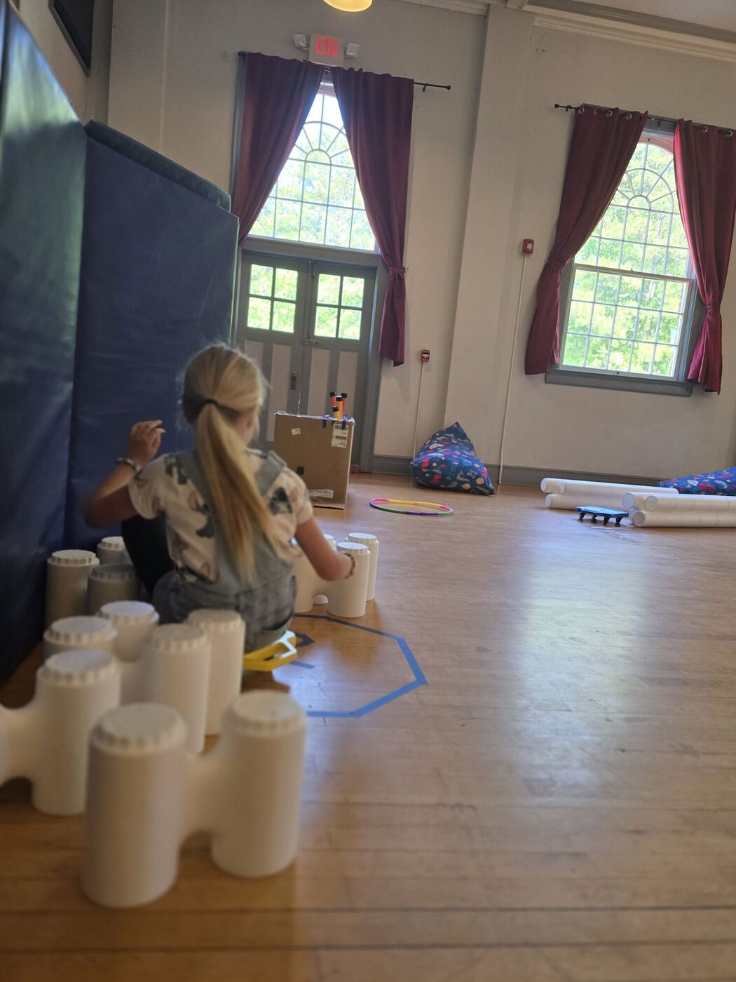 A learner from behind setting up white foam pins on the auditorium floor