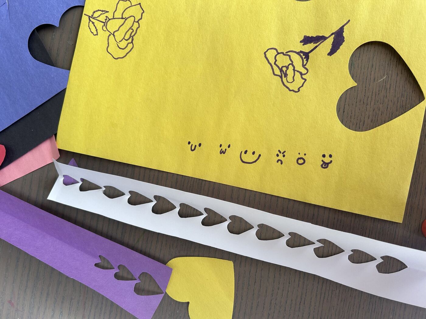 Paper heart cutouts in yellow, purple and white